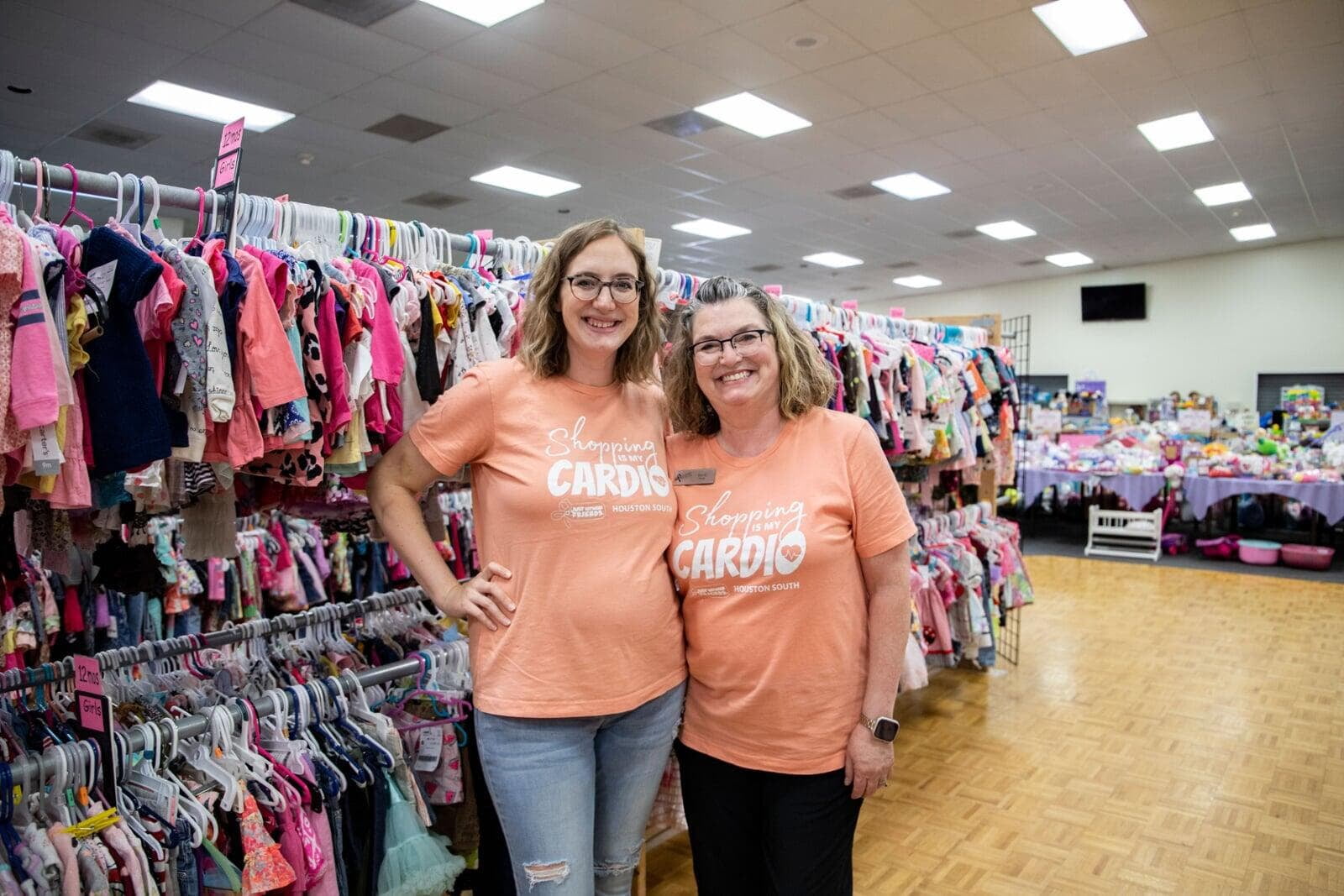 A mom and her three kids stand in front of a rack of girls clothes at their local BF sale.